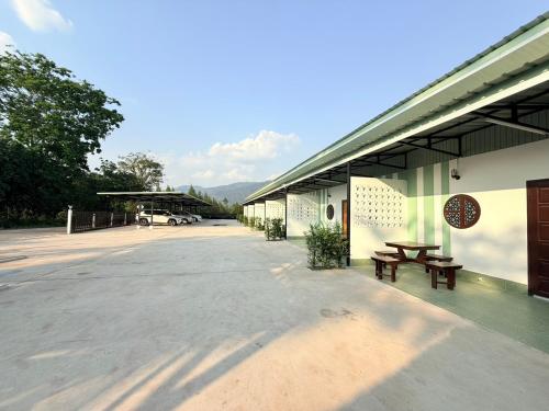 a building with two benches and a parking lot at Khaochamao View in Ban Nam Pen