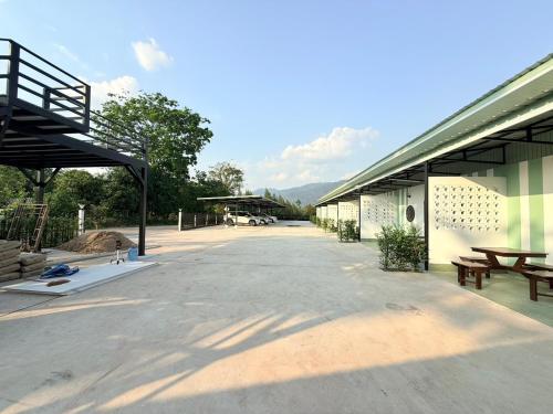 an empty parking lot with benches and a building at Khaochamao View in Ban Nam Pen