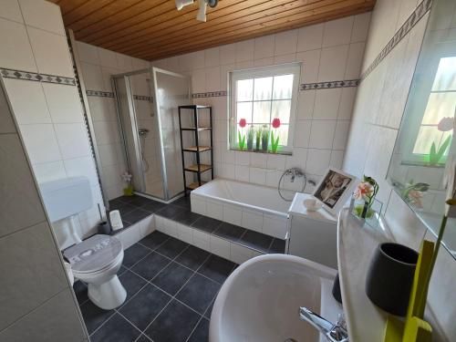 a bathroom with a tub and a toilet and a sink at Haus Perla in Saarburg
