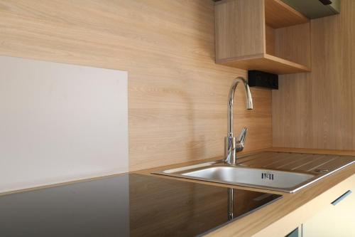 a kitchen with a sink and a wooden wall at Chalet Confort 49 in Rivières