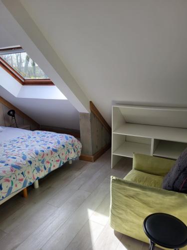 a attic bedroom with a bed and a couch at LES CANAILLOUS 4 clos la fossette Asnelles in Asnelles