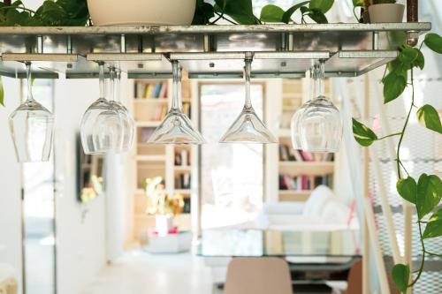 a group of wine glasses hanging from a rack in a room at Casa Utopia in Santarcangelo di Romagna