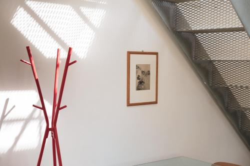 a stairwell with a picture and a vase on a wall at Casa Utopia in Santarcangelo di Romagna