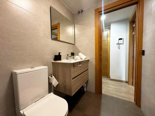 a bathroom with a toilet and a sink and a mirror at Villmor - B39 - Rabason in Benasque