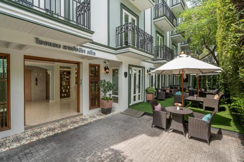 an outdoor patio with a table and chairs and an umbrella at La Petite Salil Sukhumvit Thonglor 1 in Bangkok