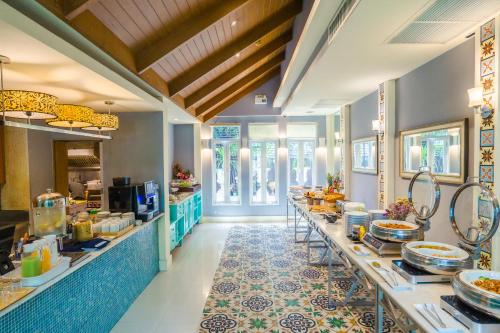 a large kitchen with a buffet line with food at La Petite Salil Sukhumvit Thonglor 1 in Bangkok