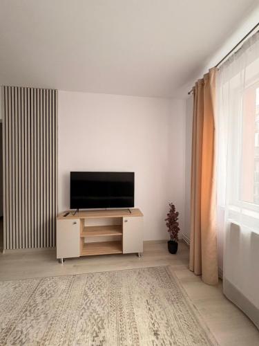 a living room with a flat screen tv on a cabinet at Comodo Apartment in Turda