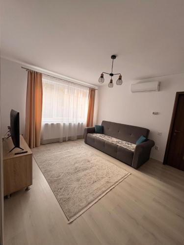 a living room with a couch and a television at Comodo Apartment in Turda