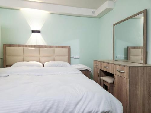 a bedroom with a large bed and a mirror at New Day Hostel in Yerevan