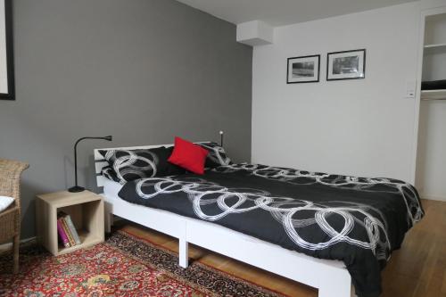 a bedroom with a bed with a black and white comforter at Wohnen am Trierer Moselufer in Trier