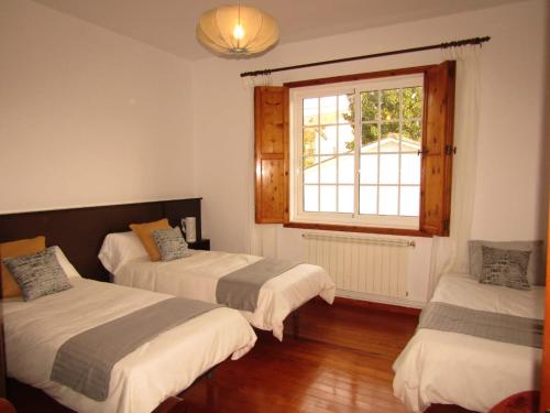 a room with two beds and a window at A Casa de Chelo in Palas de Rei