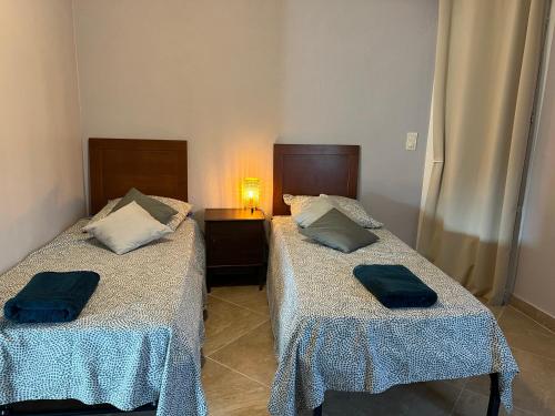 two beds sitting next to each other in a room at Ou Souleou appartement 3 étoiles dans villa Spa béton jardin vue mer et colline in Bormes-les-Mimosas