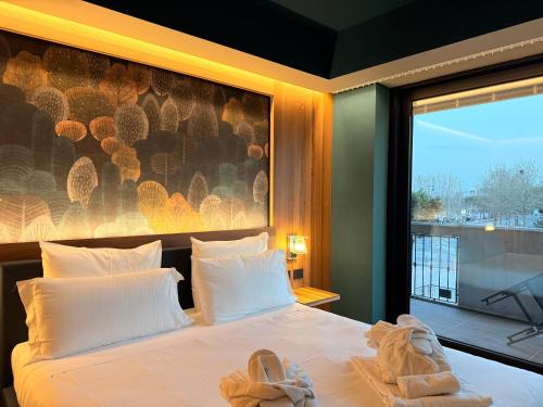 a bedroom with a bed with towels on it at Alevic Hotel Sirmione in Sirmione