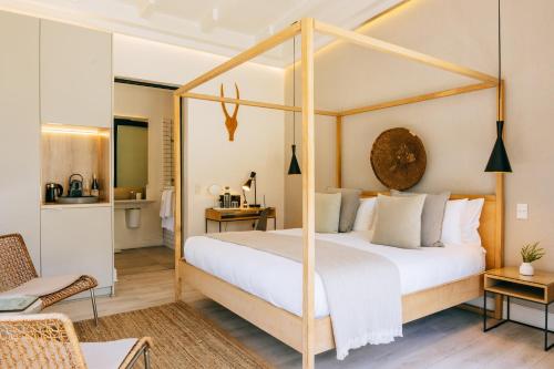 a bedroom with a canopy bed and a bathroom at Cape Diem Lodge in Cape Town