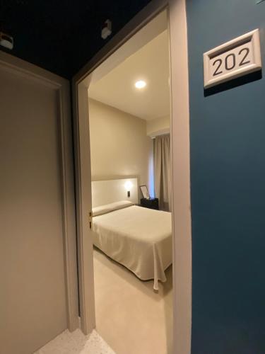 a bedroom with a bed and a sign on the door at Pensión Coral in Barcelona
