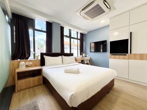 a bedroom with a large bed and a television at Aura Hotel Mackenzie in Singapore