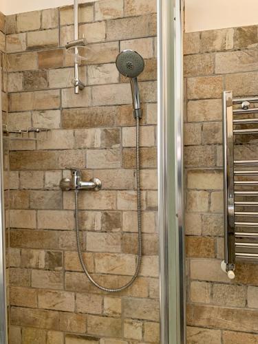 a shower with a shower head on a brick wall at Domus Serena in Venafro