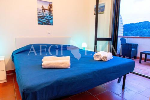 a bedroom with a blue bed with towels on it at Giglio Blu 1 in Campese