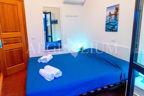 a blue bed in a room with towels on it at Giglio Blu 1 in Campese