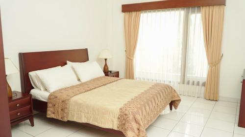 a bedroom with a bed and a large window at The Sinabung Residence Jakarta in Jakarta