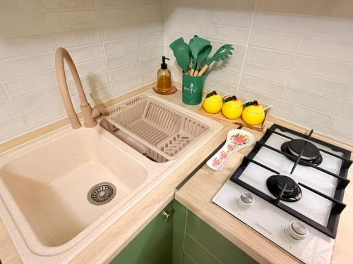 a kitchen counter with a sink and a stove at Sunny Flower in Kutaisi