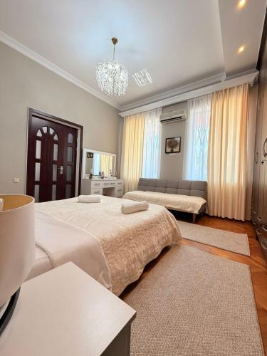 a large bedroom with two beds and a couch at Sunny Flower in Kutaisi