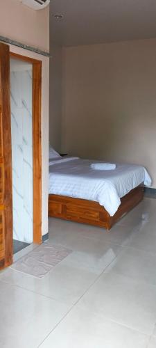 a bed with a wooden frame in a bedroom at Cozzee AnD in Labuan Bajo