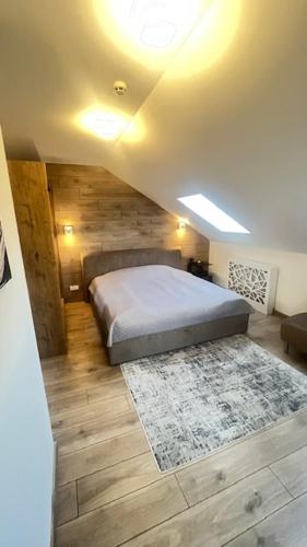 a bedroom with a bed and a rug on the floor at Čiurlioniada Apartment in Druskininkai