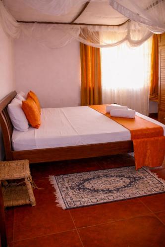 a bed in a room with a window at Elephant Villa Diani in Ukunda