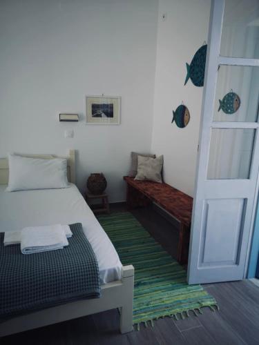 a room with a bed and a door and a bench at Fotinis Apartment in Kalymnos