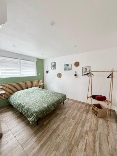 a bedroom with a bed and a table in it at Gîte chez EsTé in Mittelwihr