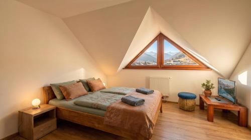 a bedroom with a bed with a large window at Biely Dom in Ružomberok