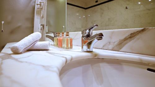 a bathroom sink with a faucet and a mirror at Best Western Grand Hotel Guinigi in Lucca