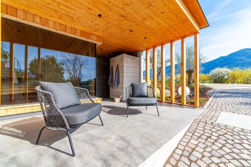 two chairs sitting on a patio with windows at Haus Wiesenstein in Lana