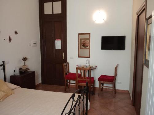 a bedroom with a bed and a table and chairs at Lunamuta b&b in Cetraro