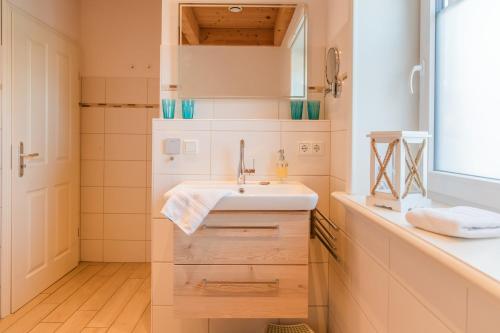 a bathroom with a sink and a mirror at Tills Hüs in Utersum
