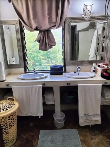 a bathroom with two sinks and a window at Rischland Villas in Watamu