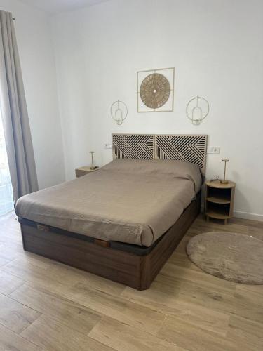 a bedroom with a large bed with a clock on the wall at Piso Loli in Águilas