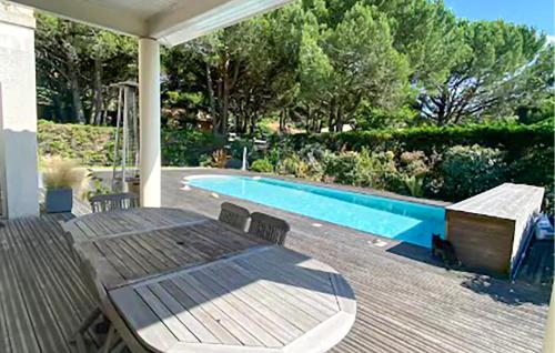 a table and chairs on a deck next to a swimming pool at Belle Maison Avec Piscine in Arcachon