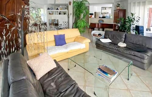 a living room with two couches and a glass table at Belle Maison Avec Piscine in Arcachon