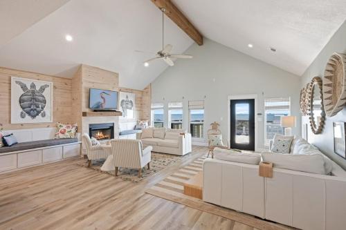 a living room with white furniture and a fireplace at Gulf State home in Crystal Beach