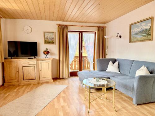 a living room with a blue couch and a table at Ferienhaus Cosima in Schwangau