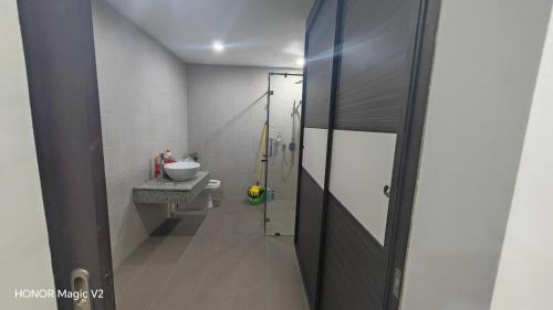 a bathroom with a sink and a toilet in it at Pearl Regency Super Condominium in Gelugor