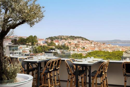 a balcony with tables and chairs and a view of the city at Tivoli Avenida Liberdade Lisboa – A Leading Hotel of the World in Lisbon
