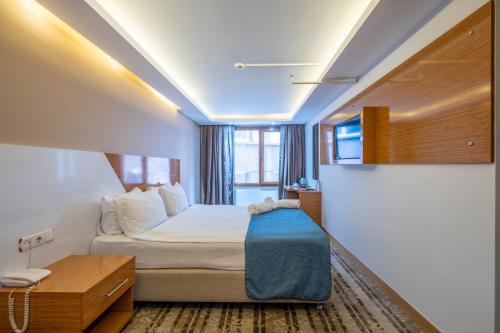 a hotel room with a bed and a window at Bulvar Hotel in İzmir