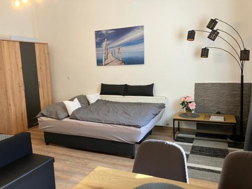 a bedroom with a bed and a table and a lamp at Holling apartman in Fertőboz