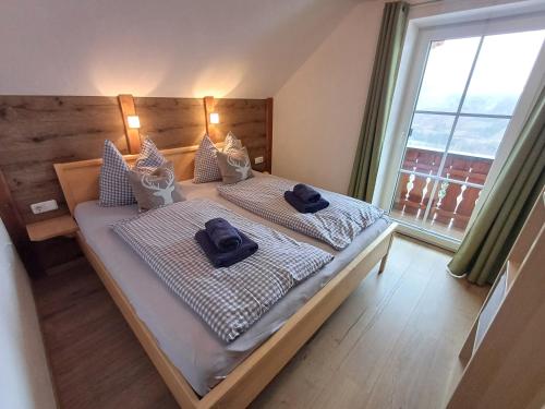 a bedroom with a bed with two blue towels on it at Panoramahof Gupf in Gröbming