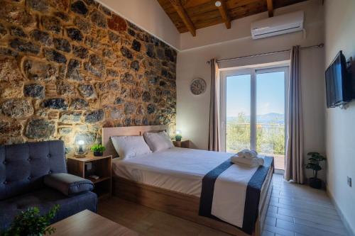 ein Schlafzimmer mit einem Bett und einer Steinwand in der Unterkunft Lithino Rooms Kalamata in Kalamata