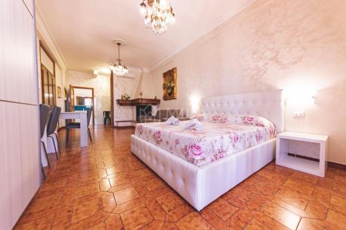 a bedroom with a white bed with a pink bedspread at Porto Cesareo - Appartamenti e camere in Porto Cesareo