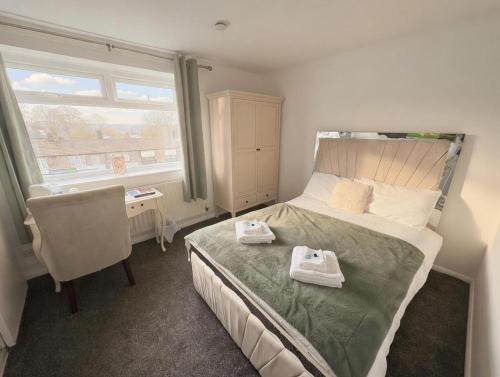 a bedroom with a bed and a chair and a window at Peasehill StMichaels in Rawdon